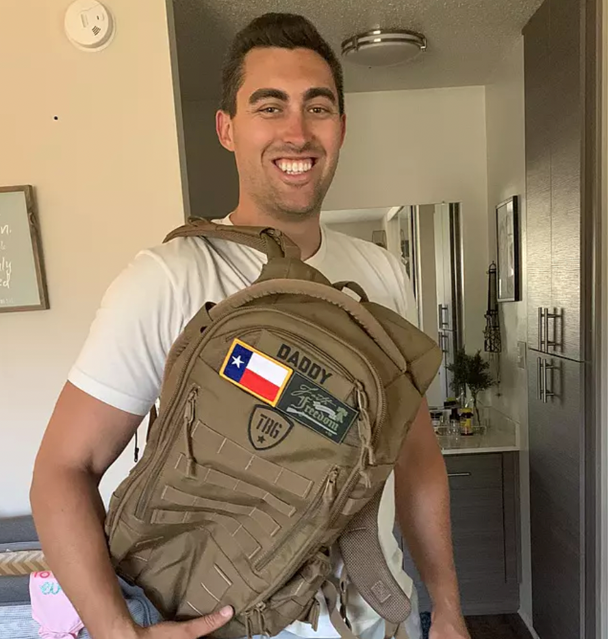 Dad smiling with child and tactical backpack