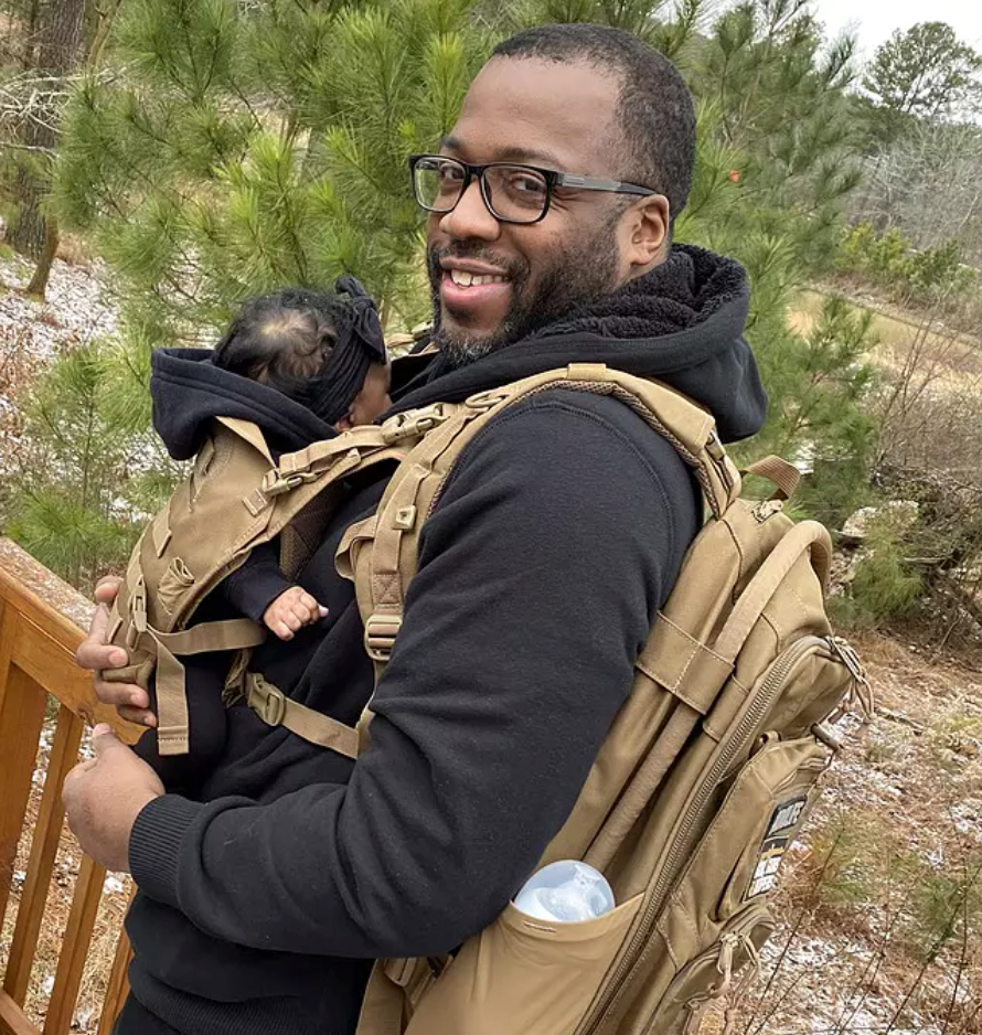 Dad wearing TBG carrier and backpack outdoors